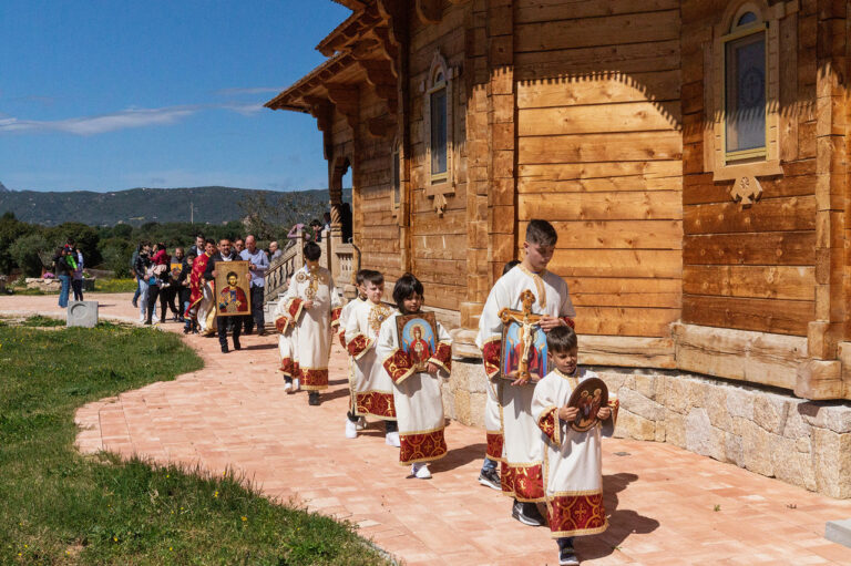 processione di fedeli ortodossi, con dei bambini che portano delle icone e altri fedeli che seguono, vicino alla chiesa ortodossa di Olbia